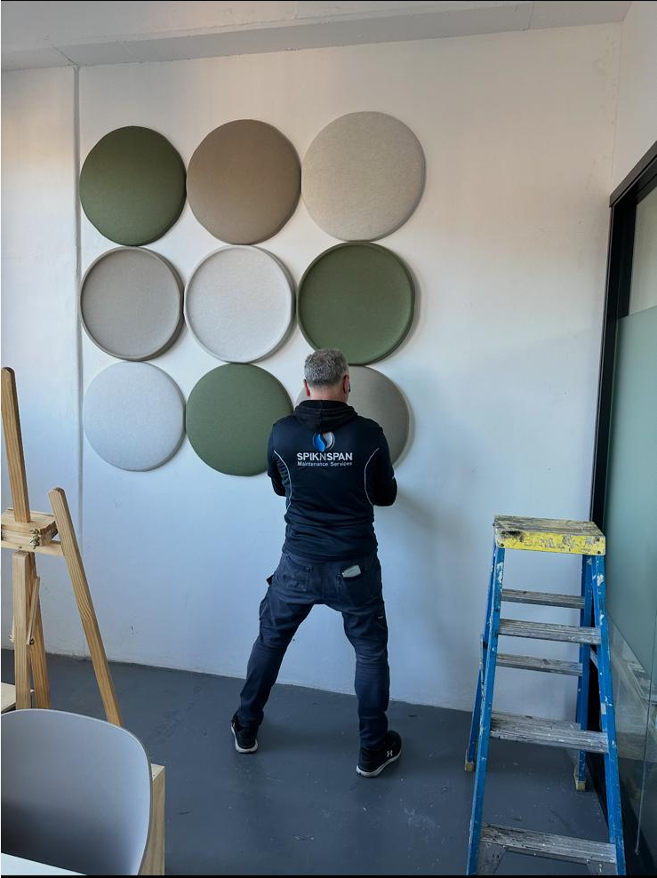 A Spik N Span technician installing acoustic panels